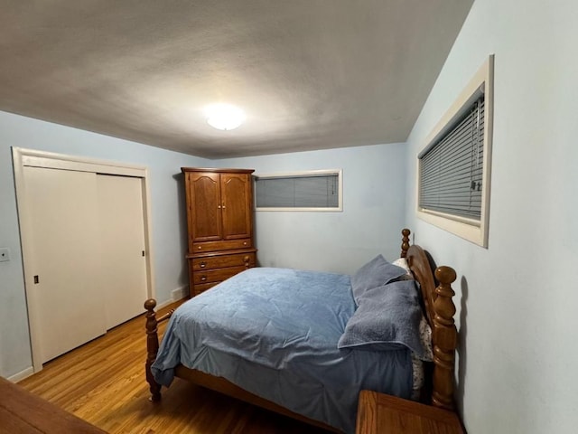 bedroom with light hardwood / wood-style floors and a closet