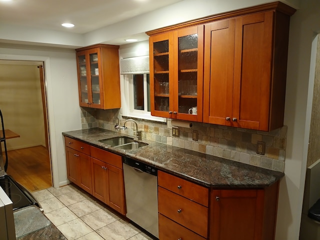 kitchen with backsplash, dark stone countertops, sink, and stainless steel dishwasher