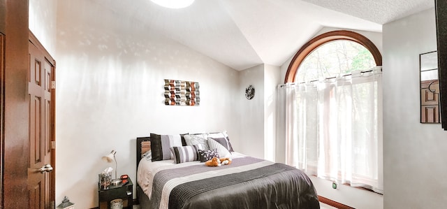 bedroom featuring a textured ceiling and vaulted ceiling