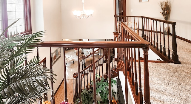 stairway featuring carpet flooring and a notable chandelier