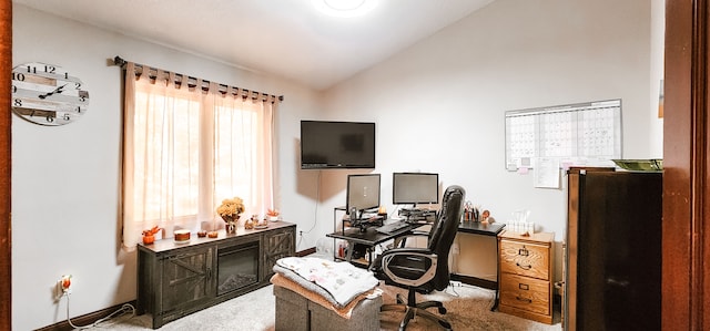 carpeted home office featuring vaulted ceiling