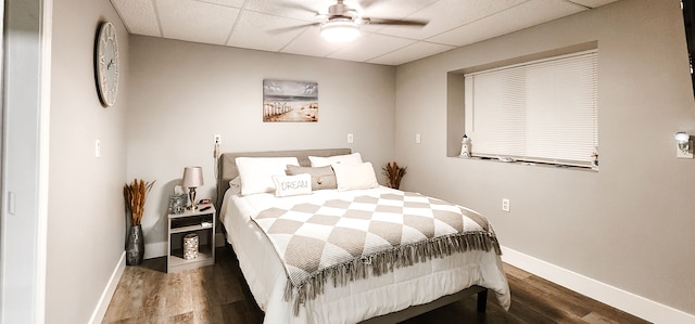 bedroom featuring a paneled ceiling, dark hardwood / wood-style floors, and ceiling fan