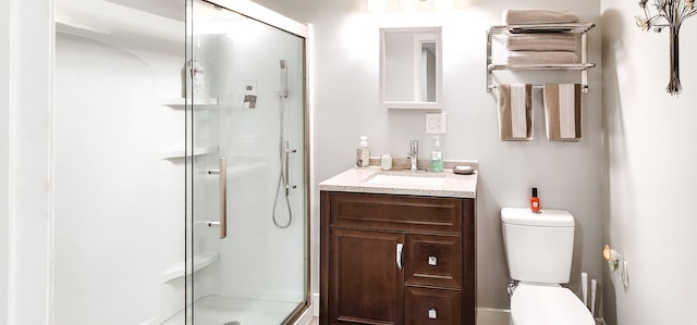 bathroom with vanity, toilet, and a shower with shower door