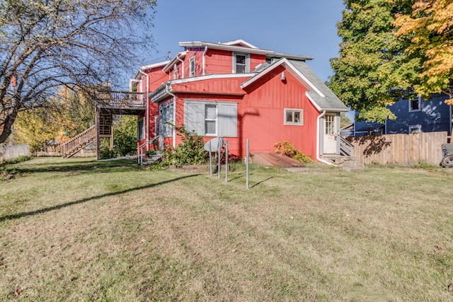 rear view of house with a lawn and a deck