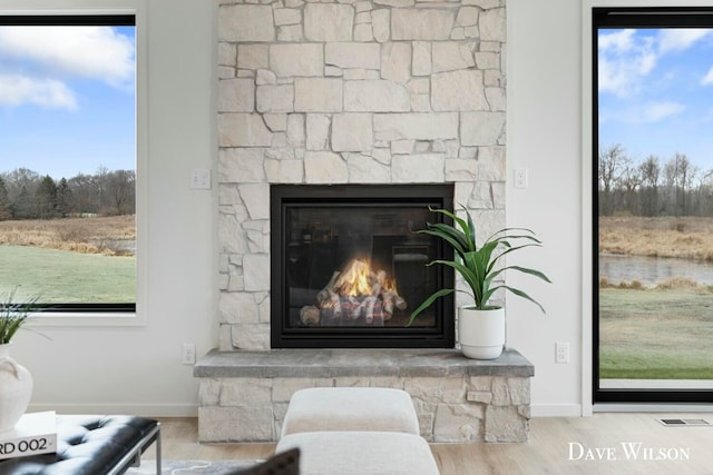 interior details featuring a stone fireplace and hardwood / wood-style floors