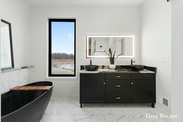 bathroom with vanity and a tub