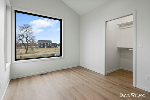 unfurnished bedroom featuring multiple windows, a closet, and light wood-type flooring