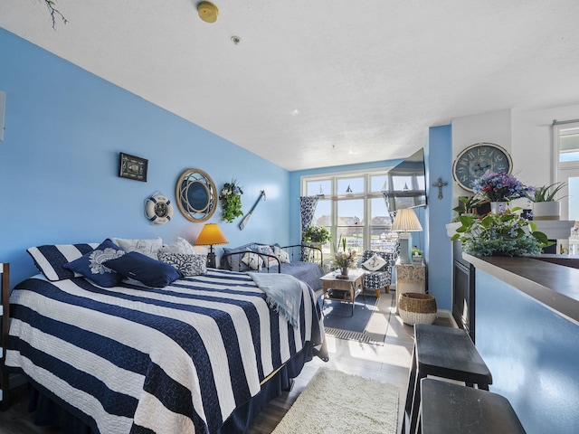 bedroom with hardwood / wood-style floors and a textured ceiling