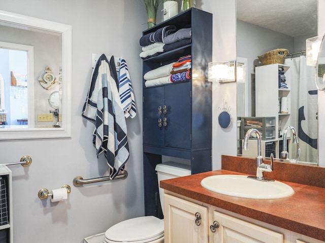 bathroom with vanity, toilet, and a textured ceiling