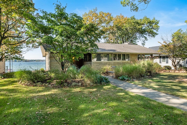 ranch-style house with a front yard and a water view