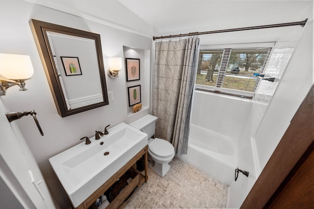 bathroom featuring toilet, shower / bath combo with shower curtain, and a sink