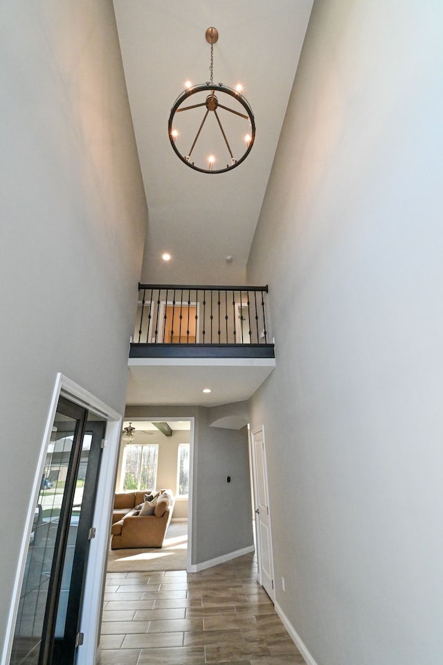 interior space featuring wood-type flooring, high vaulted ceiling, and an inviting chandelier