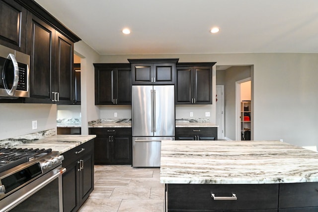 kitchen featuring light stone countertops, appliances with stainless steel finishes, and a kitchen island