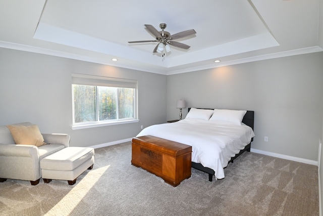 carpeted bedroom with ceiling fan, ornamental molding, and a tray ceiling