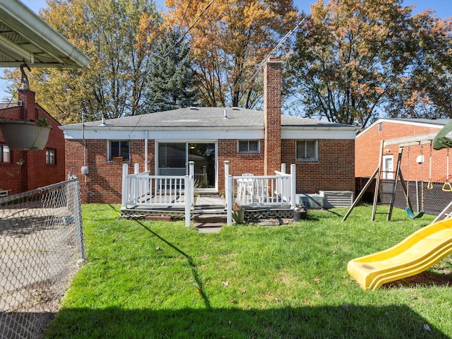 back of house featuring a yard, a playground, and a wooden deck