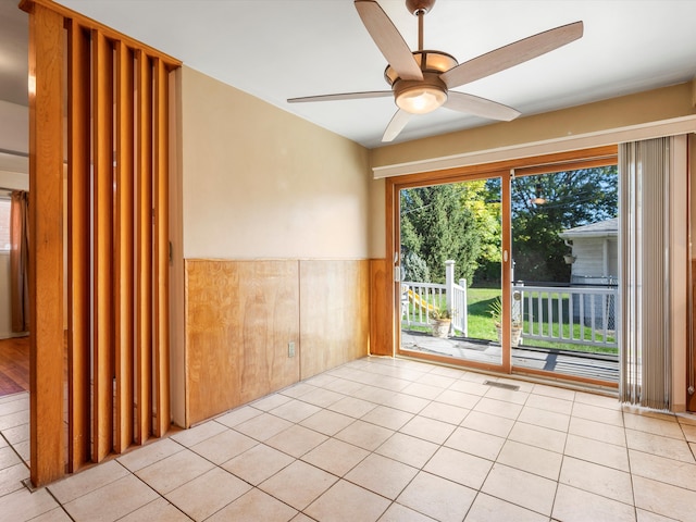 tiled empty room featuring ceiling fan