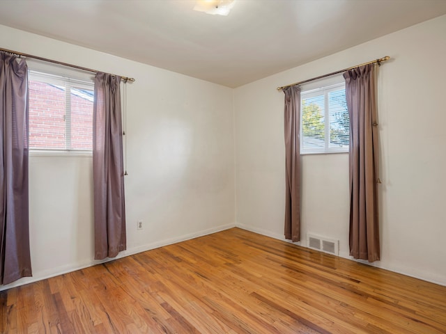 unfurnished room featuring a healthy amount of sunlight and light hardwood / wood-style flooring