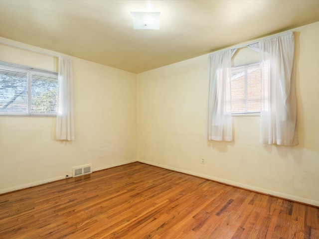 unfurnished room with wood-type flooring and a wealth of natural light