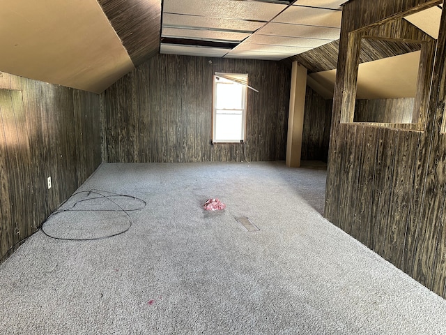 bonus room featuring lofted ceiling, carpet floors, and wooden walls