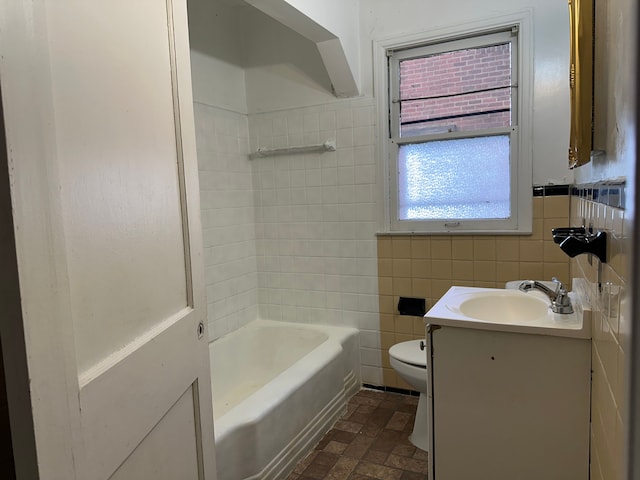 bathroom featuring vanity, toilet, and tile walls