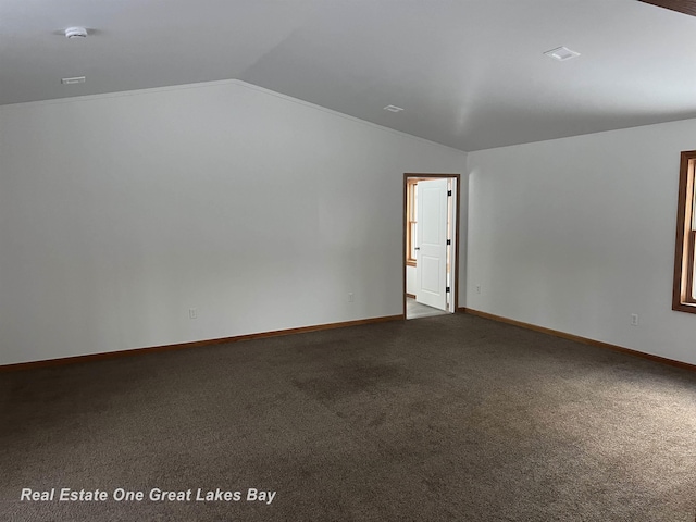 carpeted empty room with lofted ceiling