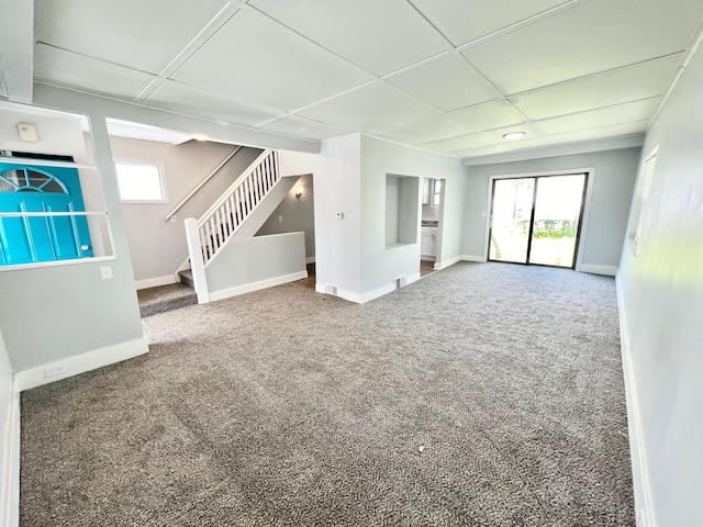 unfurnished living room with carpet and a paneled ceiling