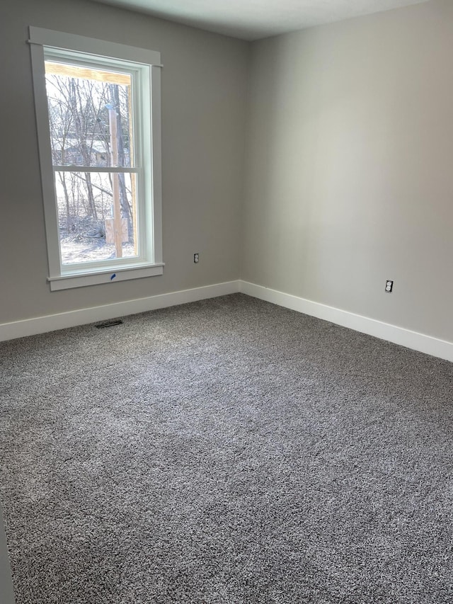 empty room with visible vents, baseboards, and carpet floors