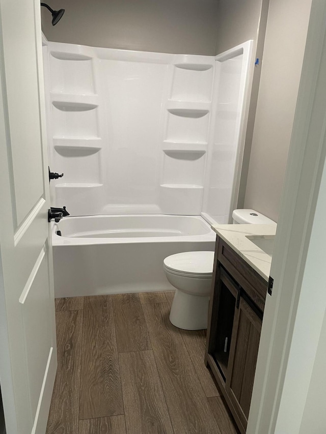 full bathroom featuring vanity, toilet, wood finished floors, and bathing tub / shower combination