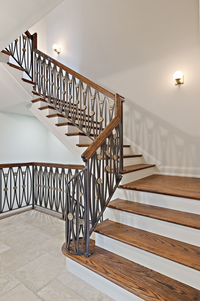 stairway featuring stone tile flooring and baseboards