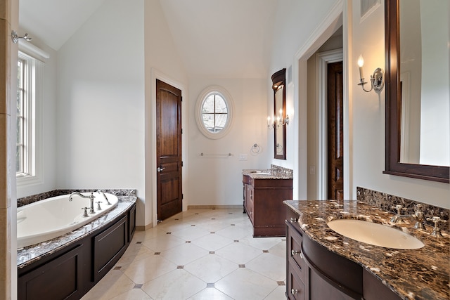 full bath featuring lofted ceiling, a garden tub, two vanities, a sink, and baseboards