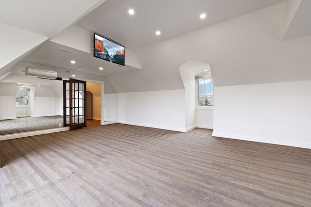 additional living space featuring carpet floors, recessed lighting, lofted ceiling, a wall mounted AC, and baseboards