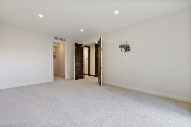 unfurnished bedroom featuring baseboards, visible vents, a walk in closet, and recessed lighting