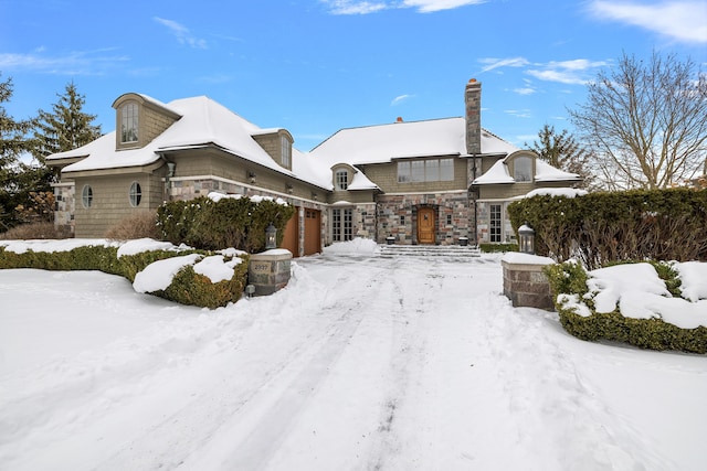 view of front facade with an attached garage and stone siding