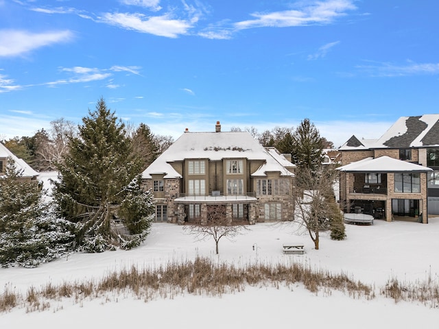 snow covered house with stone siding