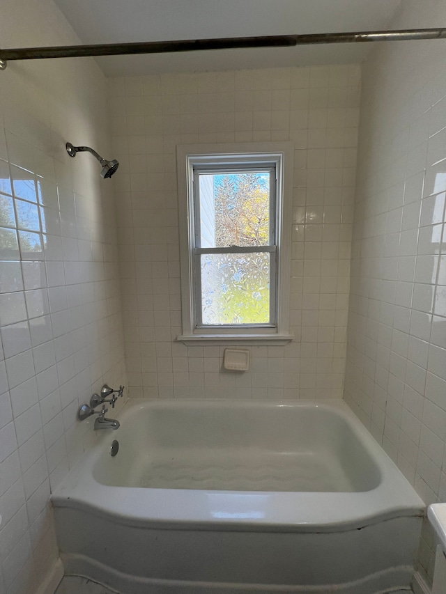 bathroom with tiled shower / bath combo and toilet