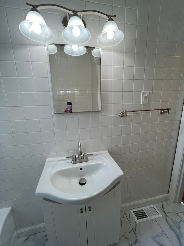 bathroom featuring vanity and tile walls