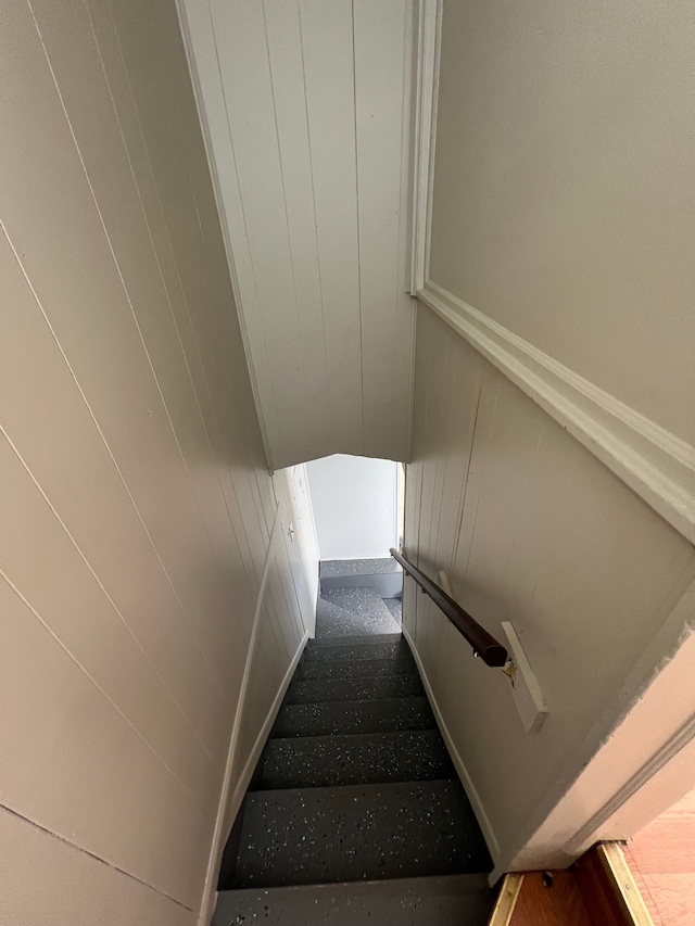 stairs featuring wood walls