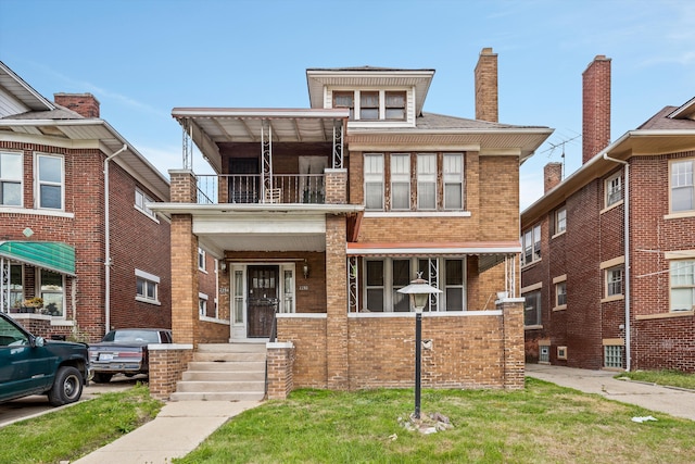 view of front facade with a balcony and a front lawn