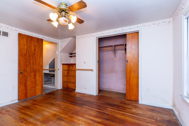 unfurnished bedroom featuring ceiling fan, dark wood-type flooring, and a closet