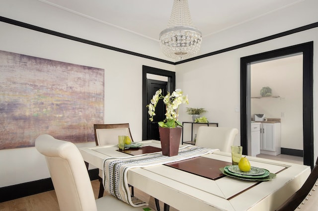 dining space with light hardwood / wood-style flooring and a chandelier