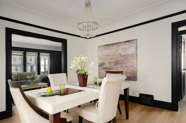 dining area featuring light wood-type flooring and a chandelier