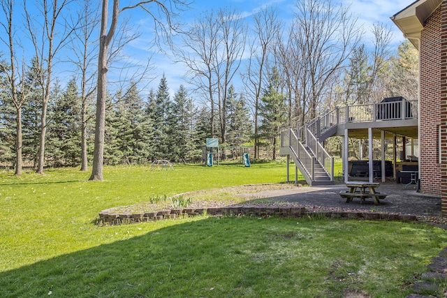 view of yard with a playground, a patio, and a deck