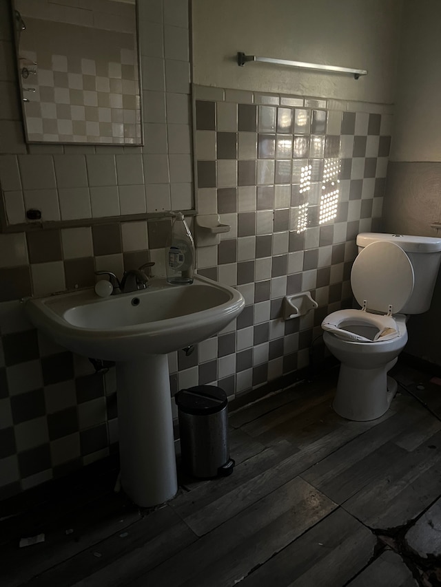 bathroom featuring hardwood / wood-style floors, tile walls, and toilet