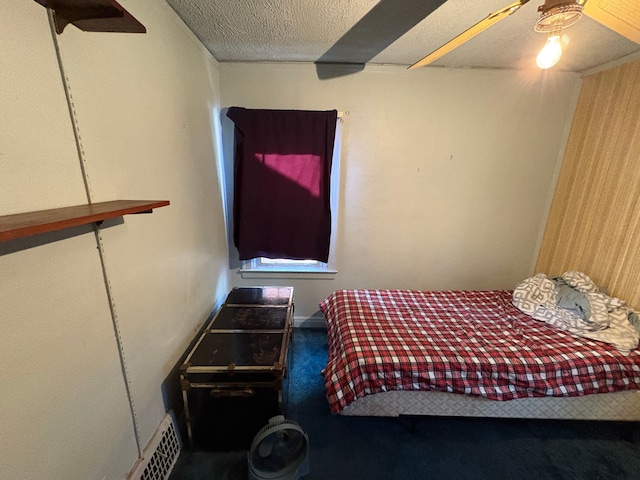 bedroom with carpet flooring, ceiling fan, and a textured ceiling