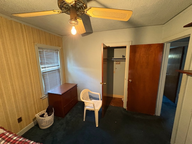 bedroom featuring ceiling fan, a closet, dark carpet, and a textured ceiling