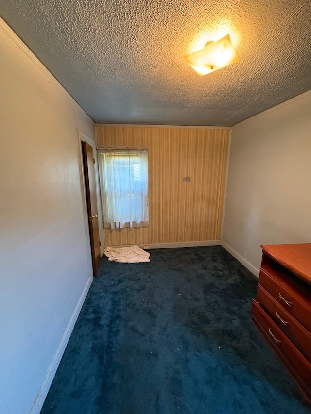 carpeted empty room featuring a textured ceiling