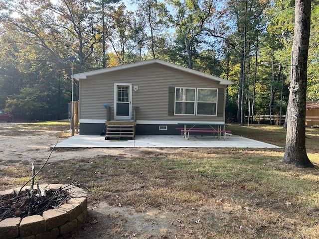 back of property featuring a lawn and a patio area