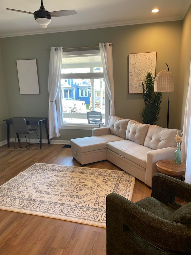 living room featuring ceiling fan, wood-type flooring, and ornamental molding