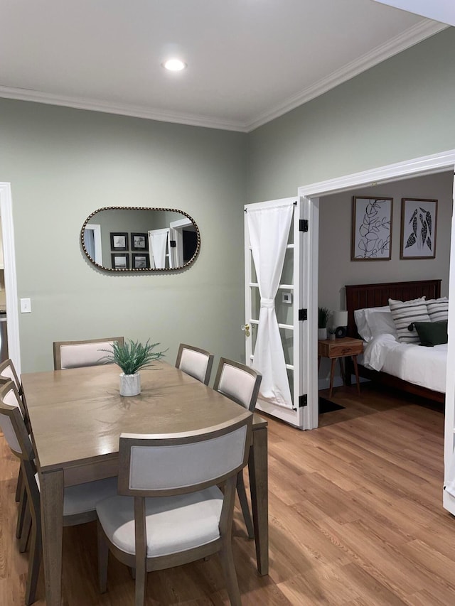 dining area featuring wood-type flooring and ornamental molding