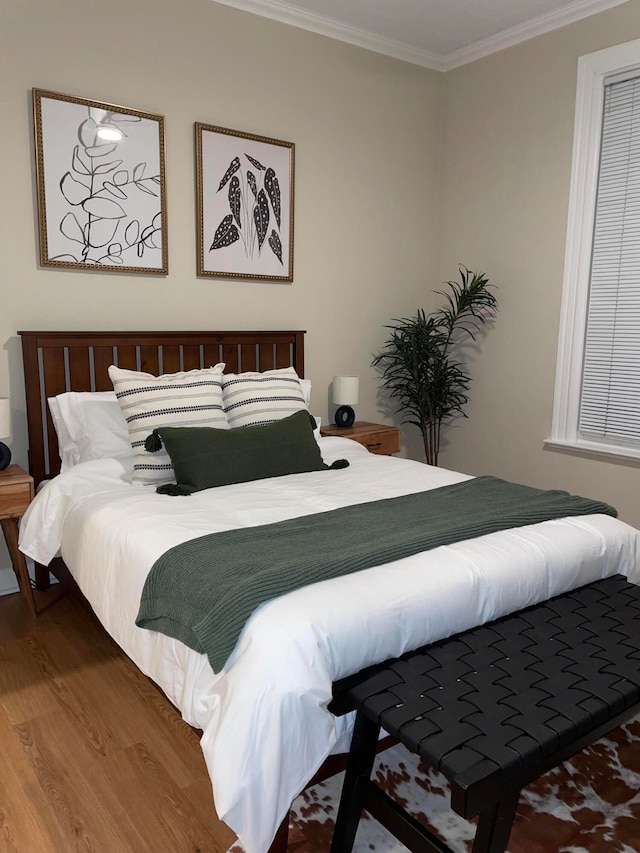 bedroom featuring wood-type flooring and ornamental molding